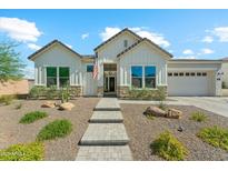 Charming single-Gathering home with board and batten siding, desert landscaping, and a welcoming walkway leading to the front door at 21391 W Mariposa St, Buckeye, AZ 85396