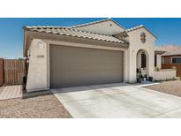 Charming home with a large garage, concrete driveway, and a low-maintenance desert-style landscape at 25915 W Tina Ln, Buckeye, AZ 85396