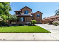 Charming two-story home featuring a well-manicured lawn and a long driveway leading to a two-car garage at 3693 E Sparrow Pl, Chandler, AZ 85286
