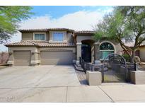 Charming two-story home features a tile roof, arched entryway, three-car garage and gated courtyard at 4530 E White Feather Ln, Cave Creek, AZ 85331