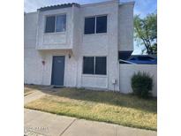 Two-story townhome featuring a textured facade, dual windows, and a front door with address numbers at 5233 N 42Nd Dr, Phoenix, AZ 85019