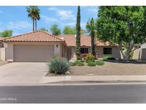 Charming home with a two-car garage, desert landscaping, and a well-maintained tile roof at 5758 E Fox St, Mesa, AZ 85205