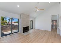 Bright living room featuring vaulted ceilings, cozy fireplace, and sliding glass doors at 7810 E Via Camello -- # 72, Scottsdale, AZ 85258