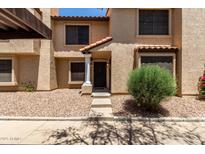 Charming townhome featuring a covered carport, desert landscaping, and inviting front entryway at 921 W University Dr # 1232, Mesa, AZ 85201