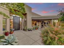 Desert home featuring a courtyard entry with unique architecture and lush vegetation at 10638 E Honey Mesquite Dr, Scottsdale, AZ 85262