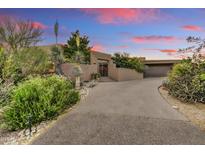 Stunning home exterior featuring desert landscaping and an inviting entryway at sunset at 10638 E Honey Mesquite Dr, Scottsdale, AZ 85262