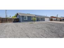 Charming single-story home featuring solar panels, a gravel front yard and a side garage at 11012 E Elton Ave, Mesa, AZ 85208