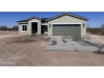Charming single story home with a two car garage, desert landscaping, and a concrete driveway at 11650 N Abel Pl, Florence, AZ 85132