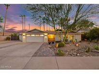 Charming single-story home with a well-manicured desert landscape and a welcoming entrance at twilight at 11822 S Coconino St, Phoenix, AZ 85044
