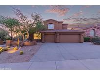 Charming two-story home with a three car garage and desert landscaping under a colorful sunset sky at 14056 E Desert Cove Ave, Scottsdale, AZ 85259