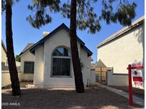 Charming single-story home with a large window, landscaped yard, and a secure gated side entrance at 1535 N Horne St # 62, Mesa, AZ 85203