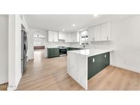 Bright kitchen boasts sleek white and green cabinets, modern appliances, and spacious quartz countertops at 18428 N 42Nd St, Phoenix, AZ 85032