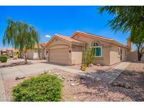 Charming single-story home featuring desert landscaping, a terracotta tile roof, and a two-car garage in a quiet neighborhood at 2015 E Glenhaven Dr, Phoenix, AZ 85048