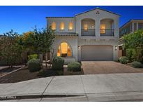 Elegant two-story home with arched windows, balcony, and a well-manicured front yard at twilight at 22306 N 34Th Pl, Phoenix, AZ 85050