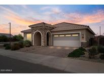 Charming single-story home featuring a two-car garage, and stone accents at the entrance, complemented by well-maintained landscaping at 25030 N 172Nd Ln, Surprise, AZ 85387