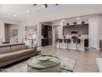 Open-concept living room and kitchen with a comfortable couch and modern bar stools at 3852 E Bartlett Way, Chandler, AZ 85249