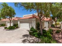 View of home with a terracotta roof, lush green landscaping, and a gated front entrance at 4225 N 21St St # 22, Phoenix, AZ 85016