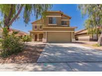 Two-story home featuring a neutral color scheme, concrete driveway, and a two-car garage at 45071 W Portabello Rd, Maricopa, AZ 85139
