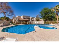 Community pool with inviting blue water, lounge chairs, and nearby landscaped community buildings at 520 N Stapley Dr # 257, Mesa, AZ 85203