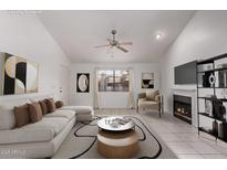 Bright living room featuring a white couch, fireplace, ceiling fan, and stylish decor at 533 W Guadalupe Rd # 2126, Mesa, AZ 85210