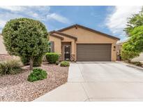 Charming single-story home featuring a well-manicured landscape, stone accents, and a two-car garage at 607 W Tenia Trl, San Tan Valley, AZ 85140