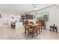 Open-concept kitchen featuring an island with seating, modern appliances, and an adjacent dining area at 607 W Tenia Trl, San Tan Valley, AZ 85140