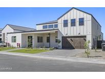 Modern two-story home featuring a landscaped front yard and a dark brown, wooden two-car garage door at 8503 S 9Th Dr # 17, Phoenix, AZ 85041