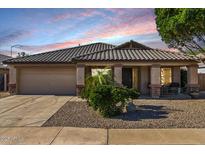 Charming single-story home featuring a tile roof, stone accents, covered porch and desert landscaping at 9632 E Olla Ave, Mesa, AZ 85212