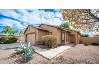 Charming single-story home with a well-maintained front yard, showcasing a neutral color palette at 10377 W Yukon Dr, Peoria, AZ 85382