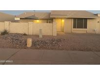 Charming single-story home with neutral toned exterior, a rock yard, and a quaint patio umbrella at 1055 N 86Th Pl, Scottsdale, AZ 85257