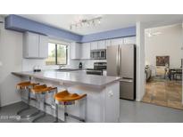 Bright kitchen boasts stainless steel appliances, ample counter space, and stylish bar seating at 1124 E Rose Ln # 17, Phoenix, AZ 85014
