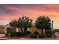 Charming single-story home features desert landscaping and a warm exterior paint color, highlighted by a beautiful sunset sky at 13414 W San Pablo Dr, Sun City West, AZ 85375