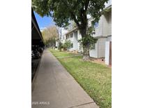 Inviting exterior view of the townhouse complex, showcasing well-maintained landscaping and charming architecture at 2530 W Berridge Ln # E111, Phoenix, AZ 85017