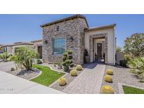 Charming home featuring a stone facade, desert landscaping, and a welcoming brick walkway at 35486 N Morello Dr, Queen Creek, AZ 85140
