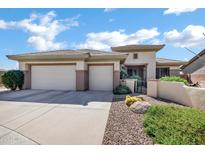 Inviting single-story home with a three-car garage and desert landscaping in front yard at 41215 N Lytham Ct, Phoenix, AZ 85086