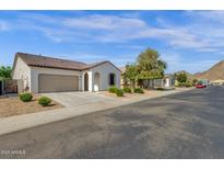 A view of the home's facade showcasing its desert landscaping in a well-maintained community at 4595 W Foldwing Dr, San Tan Valley, AZ 85144