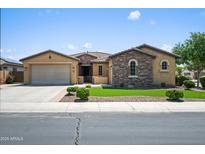 Charming single-story home with a two-car garage and stone accents, showcasing manicured landscaping and inviting curb appeal at 4721 N Aldea W Rd, Litchfield Park, AZ 85340