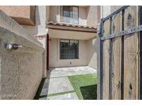 Inviting townhome entry featuring stone pavers, a touch of green turf, and gate access to the cozy front patio at 818 S Westwood -- # 101, Mesa, AZ 85210