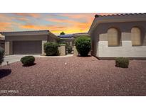 Charming single-story home featuring a two-car garage and a beautifully landscaped front yard with desert gravel and mature shrubs at 12826 W La Vina Dr, Sun City West, AZ 85375