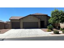 Charming single-story home with a three-car garage, mature landscaping, and a tile roof at 17531 W Fetlock Trl, Surprise, AZ 85387