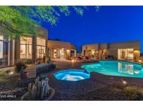 Beautiful backyard with a sparkling pool, hot tub, outdoor seating, desert plants, and a luxurious outdoor living space at 30600 N Pima N Rd # 81, Scottsdale, AZ 85266