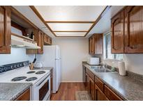 Traditional kitchen with wood cabinets, updated countertops, and white appliances at 3131 W Cochise Dr # 269, Phoenix, AZ 85051