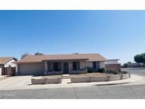 Charming single-story home featuring a well-maintained front yard and an attached garage on a sunny day at 405 E Providence Dr, Casa Grande, AZ 85122