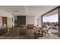 Bright and airy living space with modern fireplace, island, and dining area flowing to an outdoor patio at 4849 N Camelback Ridge Rd # B403, Scottsdale, AZ 85251