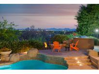 Inviting outdoor space featuring a built-in BBQ, comfortable seating around a fire pit, and a refreshing pool at 5921 E Leisure Ln, Carefree, AZ 85377