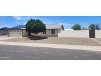 Charming single-story home featuring desert landscaping, a well-kept lawn, and a two car garage at 6104 W Marconi Ave, Glendale, AZ 85306