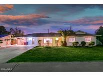 Charming single-story home featuring a lush green lawn, covered parking, and manicured landscaping at 6901 E Oak St, Scottsdale, AZ 85257