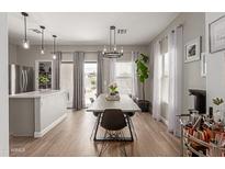 Bright dining room with sleek table, modern chandelier, and sliding glass doors for indoor-outdoor flow at 872 E Saratoga St, Gilbert, AZ 85296