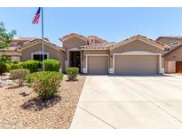 Charming single-story home boasts a two-car garage, desert landscaping, and an American flag at 927 S Ash St, Gilbert, AZ 85233