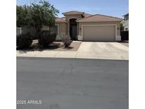 Charming single-story home showcasing a well-maintained yard and inviting two-car garage at 14991 W Shaw Butte Dr, Surprise, AZ 85379